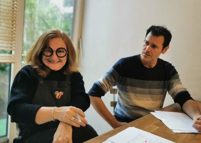 a woman sitting and a man next to her looks at her