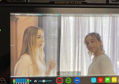 Two actresses on set viewed through the handheld monitor