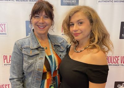 Women in front of step and repeat back drop at Playhouse West Film Festival